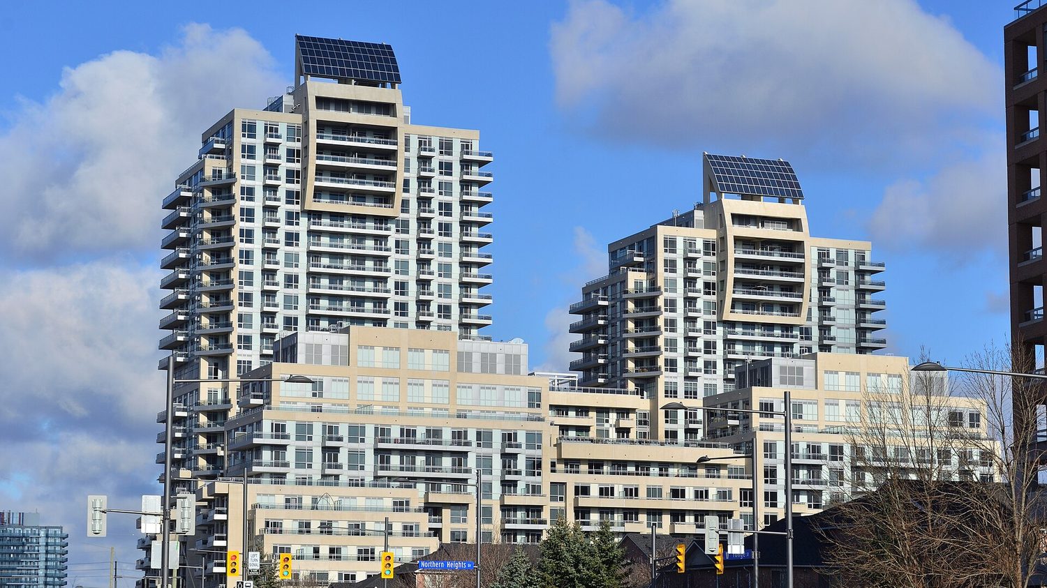 Rooftop photovoltaic array on a multi-unit building, representing the commercial and industrial load profile that behind-the-meter storage now serves