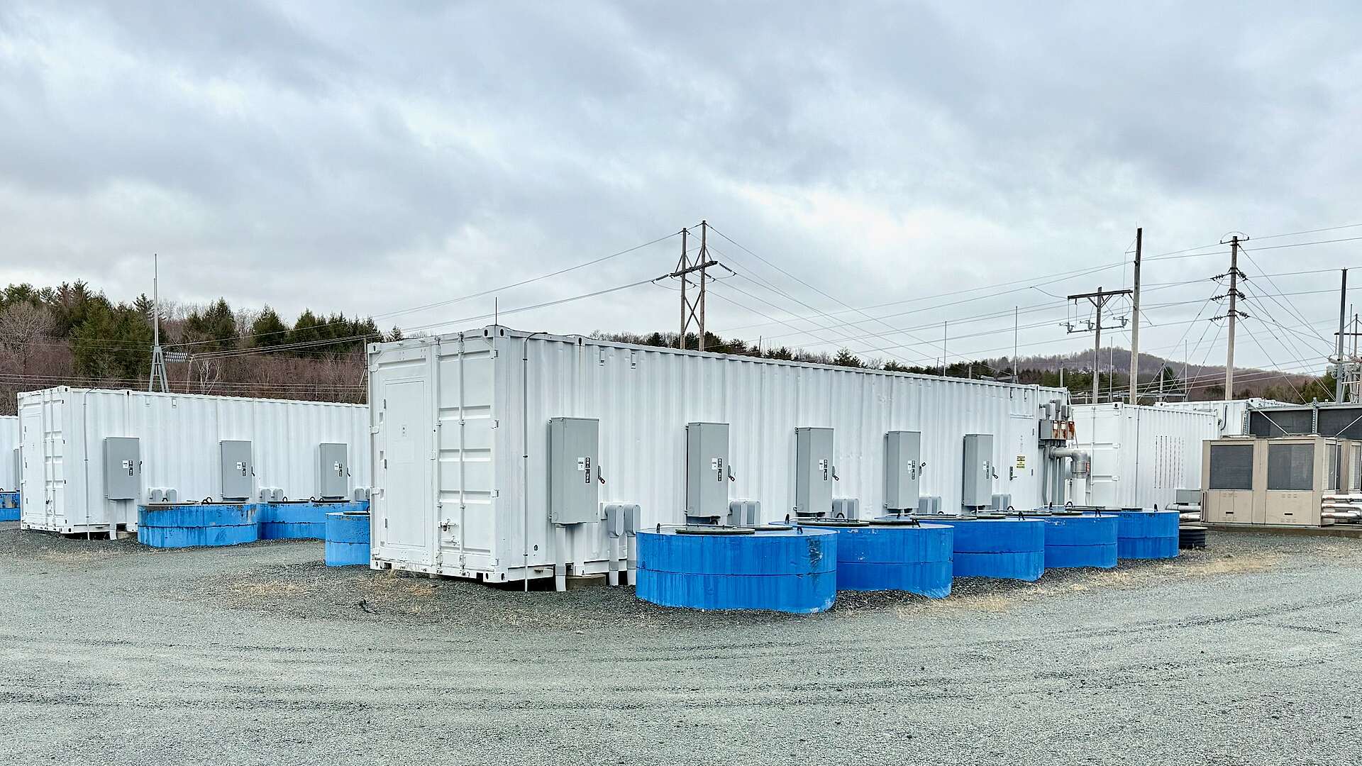 White containerized battery energy storage systems at a utility-scale BESS site for energy arbitrage