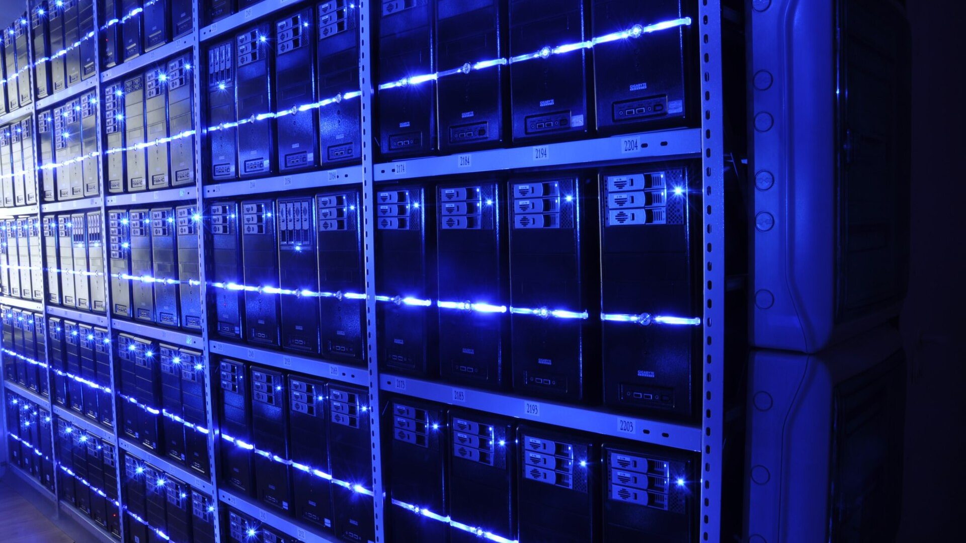 Data center server racks with blue LED lighting, backed by battery energy storage for UPS backup power